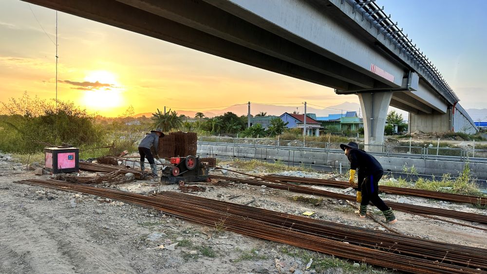 Một số công nhân làm việc dưới chân cầu vượt Thuận Minh, gần lán trại đội thi công số 3, gói XL04 chiều 21.11. Ảnh: Duy Tuấn