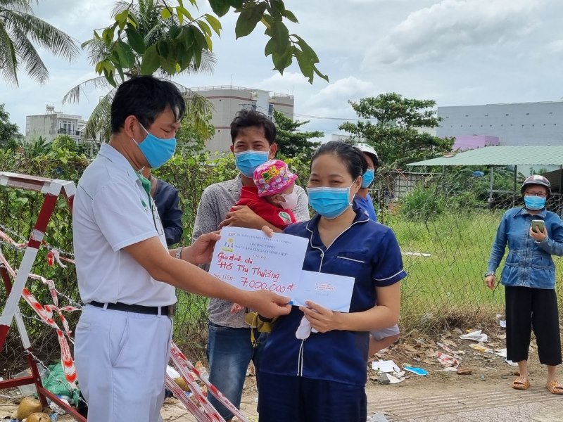 Ông Lưu Kim Hồng - Chủ tịch CĐ Công ty Nidec Việt Nam - trao quà của nhà hảo tâm cho gia đình chị Hồ Thị Thương . Ảnh: Nam Dương