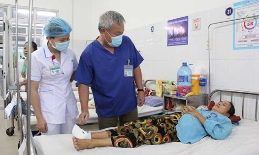 Bác sĩ Phạm Trần Xuân Anh (áo xanh đậm) thăm khám cho người bệnh. Ảnh: Nguyên Thi
