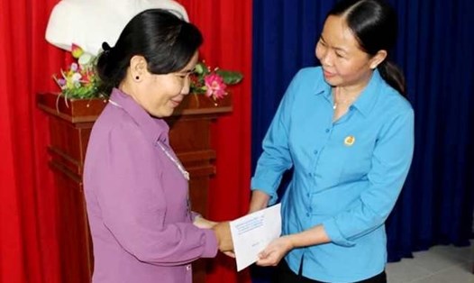 Phó chủ tịch LĐLĐ tỉnh Cà Mau Lưu Thị Trúc Ly trực tiếp trao tiền cho người lao động gặp khó khăn. Ảnh: Thiệu Vũ