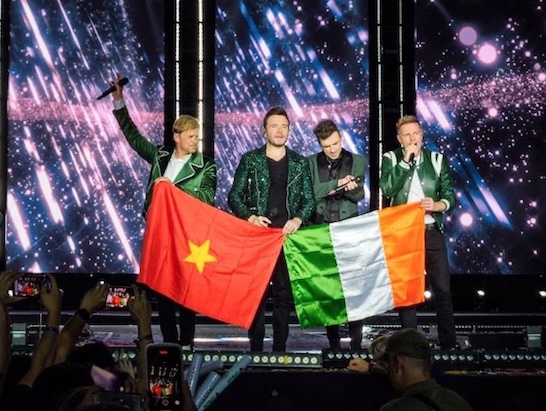 Ban nhạc Westlife trân trọng giương cao lá cờ Việt Nam cùng cờ Ireland và cúi chào khán giả. Ảnh: VPBank