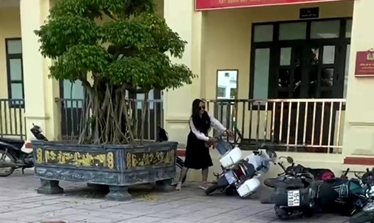Người phụ nữ có hành vi đạp, đẩy đổ hàng loạt xe máy tại trụ sở UBND xã An Đồng. Ảnh: Cắt từ clip