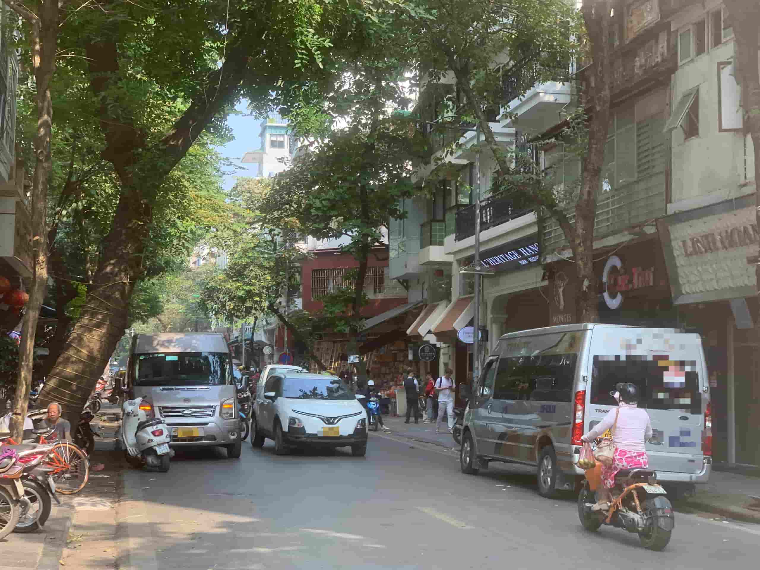 Tại phố Hàng Gà (Hoàn Kiếm, Hà Nội), ở cả hai chiều đều có xe 16 chỗ dừng đợi khách. Ảnh: Nhật Minh