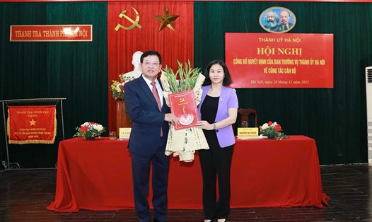 Phó Bí thư Thường trực Thành ủy Nguyễn Thị Tuyến trao quyết định, tặng hoa chúc mừng ông Trần Đức Hoạt. Ảnh: Hanoi.gov.vn