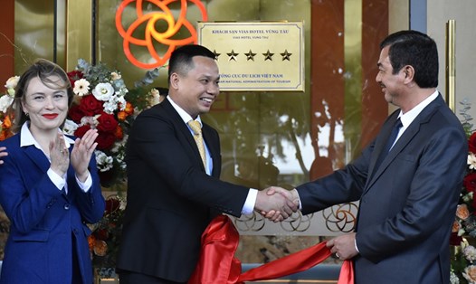 Ông Trịnh Hàng - Giám đốc Sở Du lịch (phải) trao quyết định công nhận, tham gia gắn biển tiêu chuẩn 5 sao và chúc mừng Khách sạn VIAS. Ảnh: Thành An