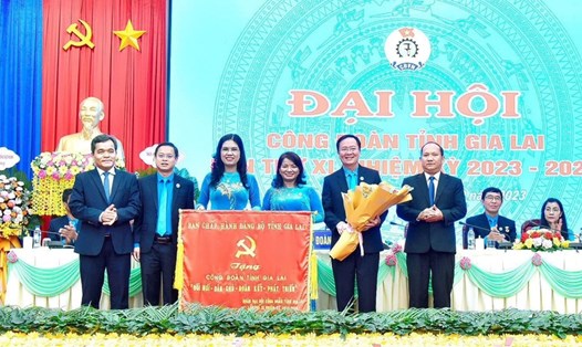 Bí thư Tỉnh ủy Gia Lai Hồ Văn Niên (ngoài cùng, bìa trái) trao cờ thi đua của BCH Đảng bộ tỉnh cho Công đoàn tỉnh tại Đại hội Công đoàn tỉnh lần thứ XI. Ảnh: Đức Thuỵ 