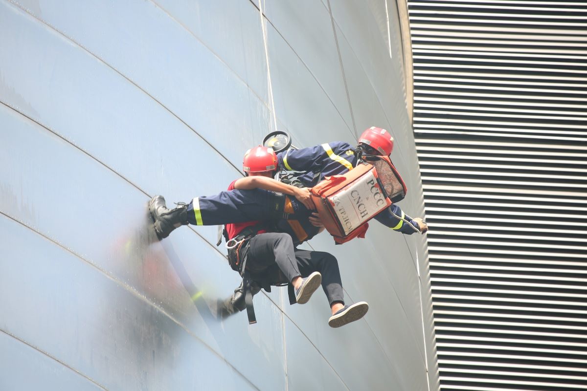 Lực lượng PCCC và cứu hộ, cứu nạn đưa nạn nhân mắc kẹt từ trên cao xuống đất an toàn.