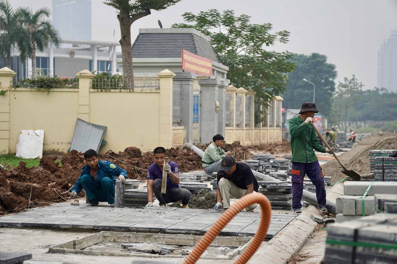 Công nhân đang lát đá vỉa hè đoạn khu vực Chi cục thi hành án Nam Từ Liêm. 