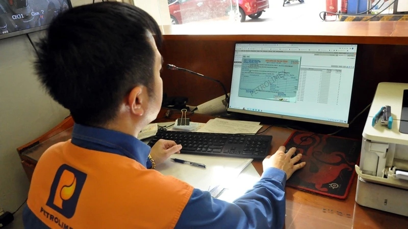 Nhân viên xuất hóa đơn ngay cho khách hàng sau khi mua xăng tại Petrolimex. 