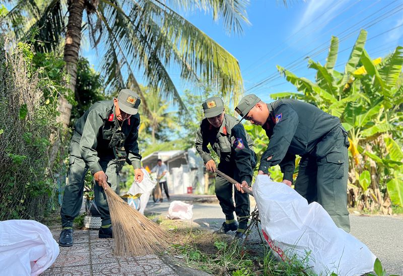 Cán bộ, chiến sĩ Cảnh sát Cơ động phát quang, dọn dẹp lòng lề đường. Ảnh: Vũ Tiến