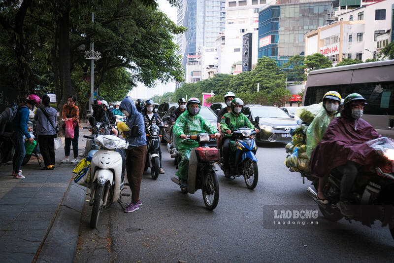 Người dân đi làm từ sớm để tránh mưa, tắc đường. Ảnh: Hiệp Phạm