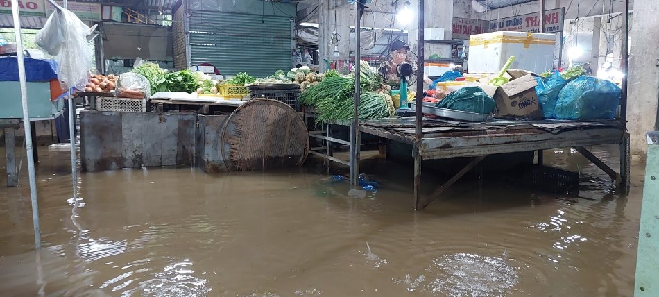 Nước tràn vào chợ Thanh Vinh, tiểu thương hối hả kê cao đồ vật. Ảnh: Văn Trực