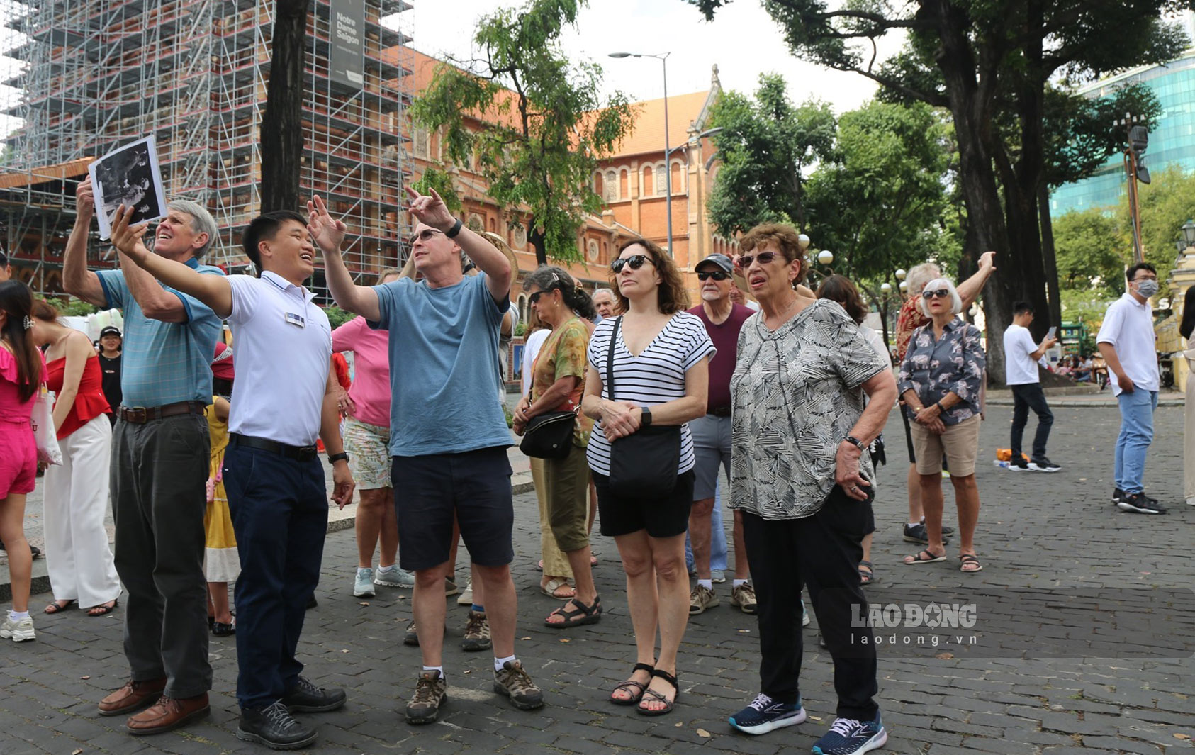 Khách nước ngoài lắng nghe hướng dẫn viên giới thiệu về các thông tin về kiến trúc và lịch sử của TPHCM hồi tháng 1.2023. Ảnh: Khánh Linh