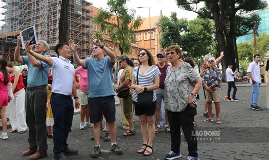 Khách nước ngoài lắng nghe hướng dẫn viên giới thiệu về các thông tin về kiến trúc và lịch sử của TPHCM hồi tháng 1.2023. Ảnh: Khánh Linh