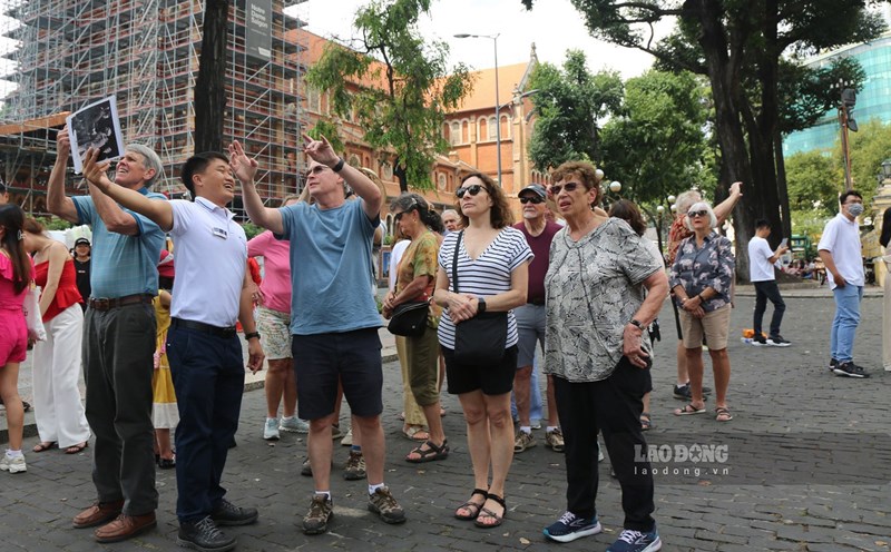 Khách nước ngoài lắng nghe hướng dẫn viên giới thiệu về các thông tin về kiến trúc và lịch sử của TPHCM hồi tháng 1.2023. Ảnh: Khánh Linh