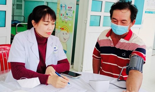 Một cán bộ dân số tham gia khám chữa bệnh cho người dân tại trạm y tế. Ảnh: Hương Giang