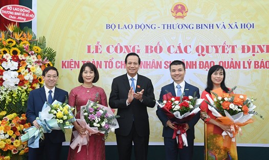 Bộ trưởng Bộ Lao động Thương binh và Xã hội Đào Ngọc Dung tặng hoa chúc mừng lãnh đạo của Báo Dân trí sau kiện toàn. Ảnh: Ái Vân