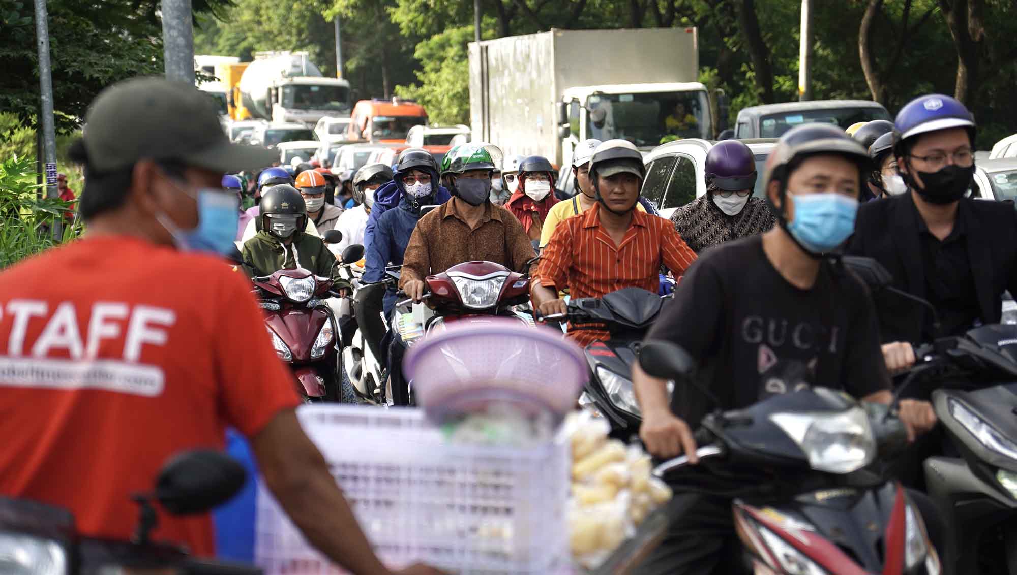 Dòng xe máy, ôtô, container nhích từng chút qua giao lộ Nguyễn Văn Linh - Nguyễn Hữu Thọ để vào trung tâm TPHCM
