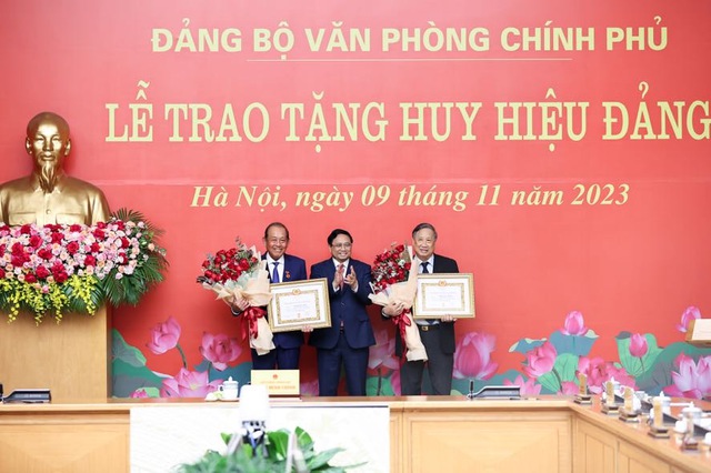 Thay mặt lãnh đạo Đảng, Nhà nước, Thủ tướng Chính phủ Phạm Minh Chính trao Huy hiệu 50 năm tuổi Đảng tặng ông Trương Hòa Bình và Huy hiệu 45 năm tuổi Đảng tặng ông Phạm Gia Khiêm. Ảnh: Nhật Bắc