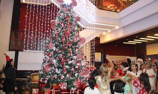 Lãnh đạo khách sạn Novotel Nha Trang và các em nhỏ cùng thắp sáng cây thông Noel mở đầu cho mùa lễ hội dành cho du khách. Ảnh: Phương Linh