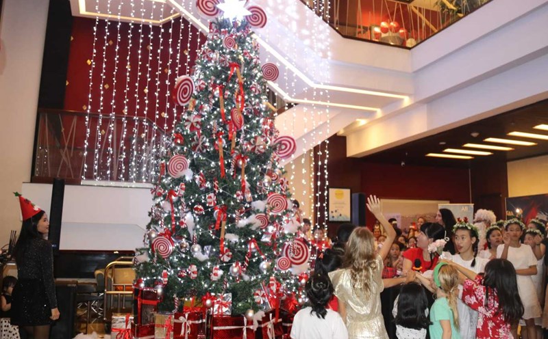 Lãnh đạo khách sạn Novotel Nha Trang và các em nhỏ cùng thắp sáng cây thông Noel mở đầu cho mùa lễ hội dành cho du khách. Ảnh: Phương Linh