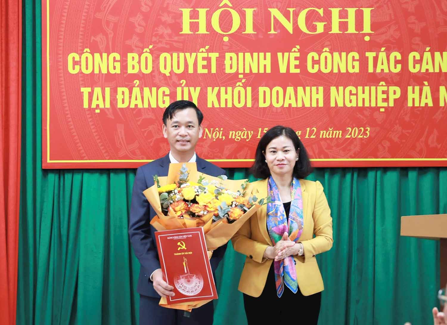 Phó Bí thư Thường trực Thành ủy Hà Nội Nguyễn Thị Tuyến trao quyết định và tặng hoa chúc mừng ông Lương Mạnh Sơn. Ảnh: Hanoi.gov.vn