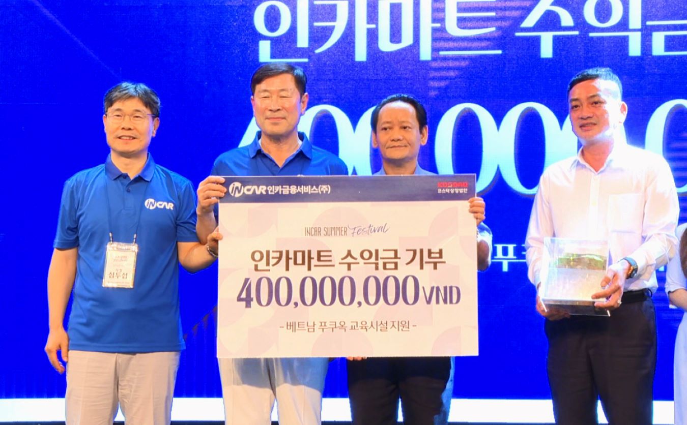 Ông Nguyễn Phú Nam (thứ 2, phải sang) tiếp nhận biển tượng trưng số tiền 400 triệu đồng từ đoàn du khách Hàn Quốc hỗ trợ an sinh giáo dục Phú Quốc. Ảnh: Mạnh Vinh 