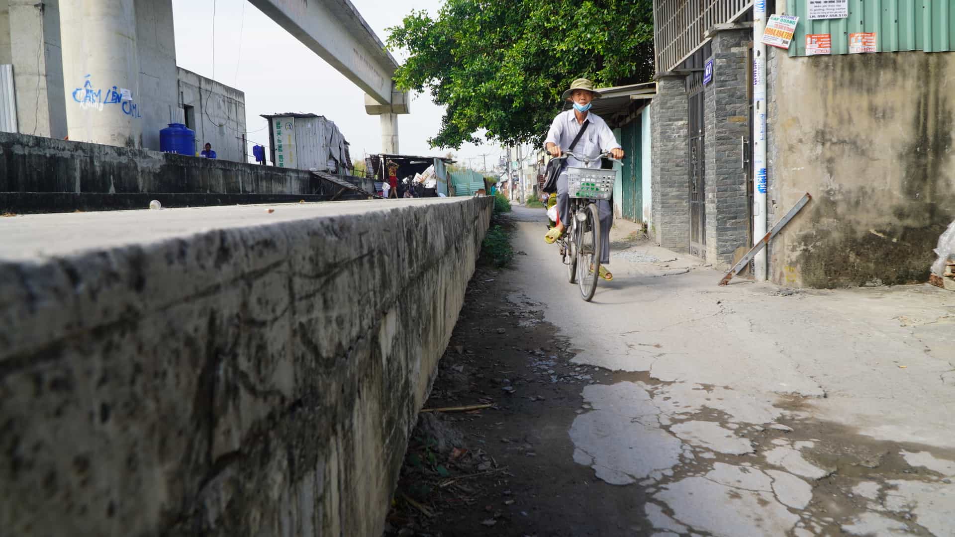 Trên đường Phú Định dự án ngăn triều xây dựng bệ móng cao 1m, rộng 2-3m, các cục bê tông, rào chắn chiếm hơn nửa mặt đường Phú Định, chỉ chừa lại khoảng 1m đường đi cho người dân khu vực này qua lại.
