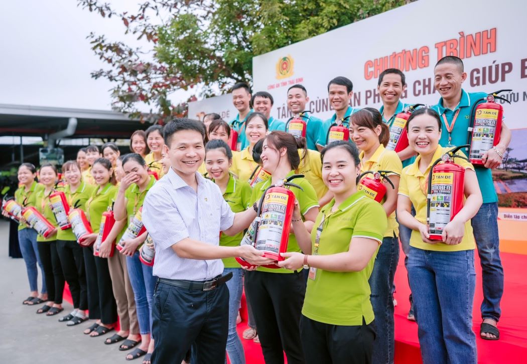 Niềm vui của công nhân Công ty Tân Đệ khi nhận bình cứu hỏa do công ty trao tặng. Ảnh: Trung Đức