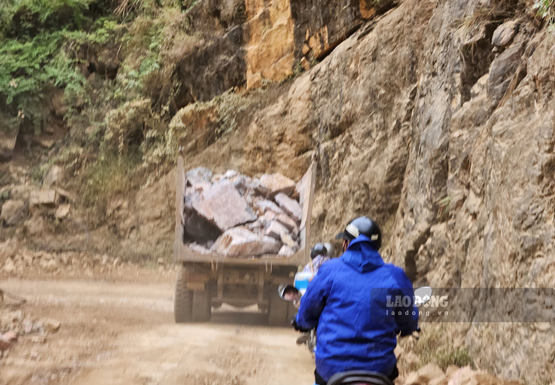 Xe máy đang đi sau một xe tải chở đầy đá hộc và không che chắn tại công trình cải tạo đèo Khau Cốc Chà. Ảnh: Tân Văn.