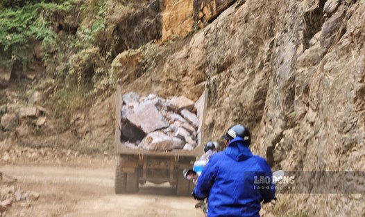 Xe máy đang đi sau một xe tải chở đầy đá hộc và không che chắn tại công trình cải tạo đèo Khau Cốc Chà. Ảnh: Tân Văn.