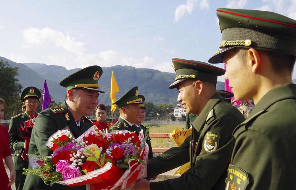 Đoàn đại biểu Bộ đội Biên phòng tỉnh Lai Châu (Việt Nam) và Đoàn đại biểu Bộ đội Biên phòng khu vực Mông Tự (Trung Quốc) BĐBP khu vực Mông Tự tặng hoa tại cầu hữu nghị Biên giới Việt – Trung. Ảnh: Đức Duẩn