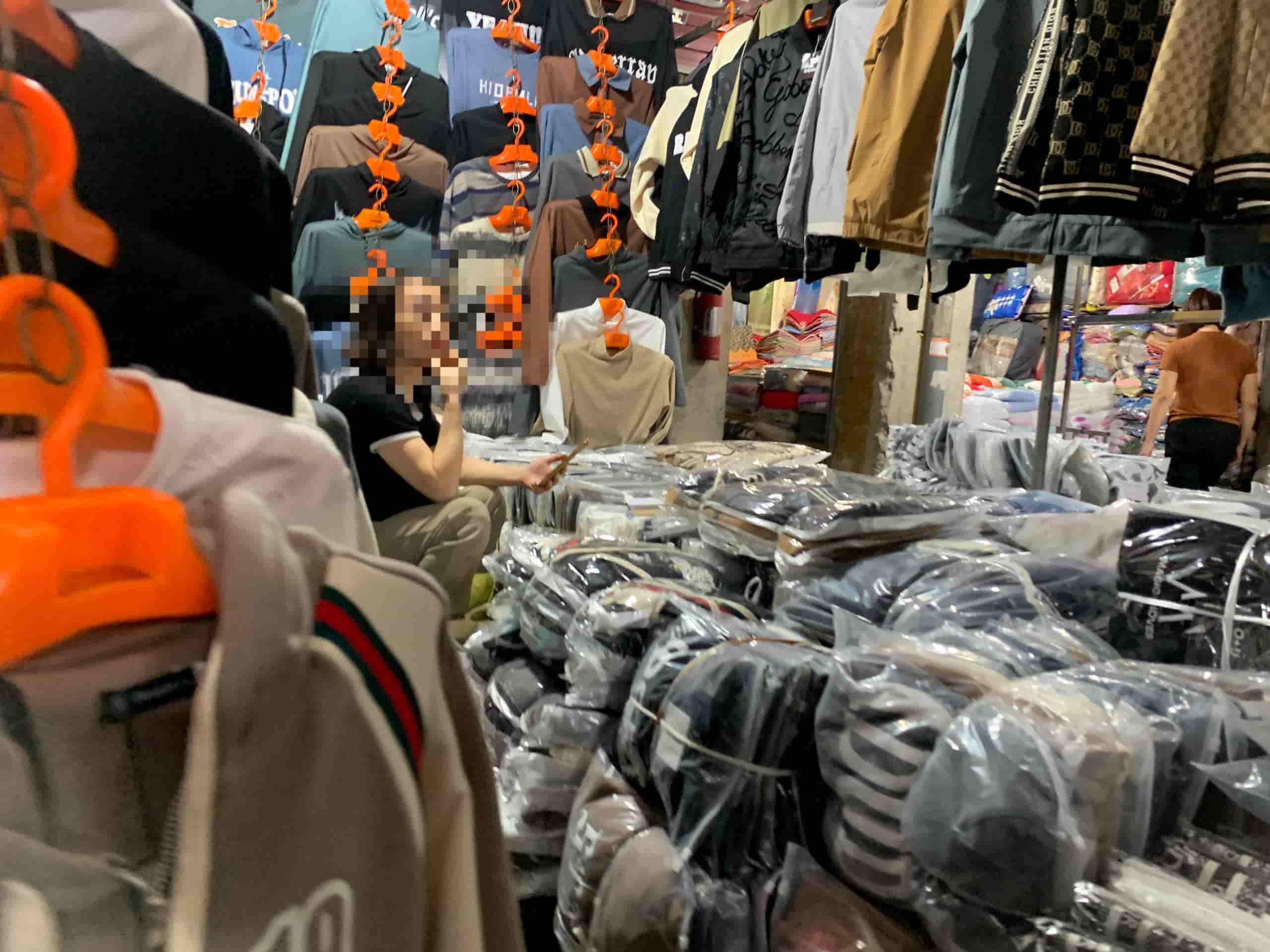 Nhiều tiểu thương ngồi bấm điện thoại chờ khách mua hàng tại chợ Ninh Hiệp (Gia Lâm, Hà Nội). Ảnh: Nhật Minh