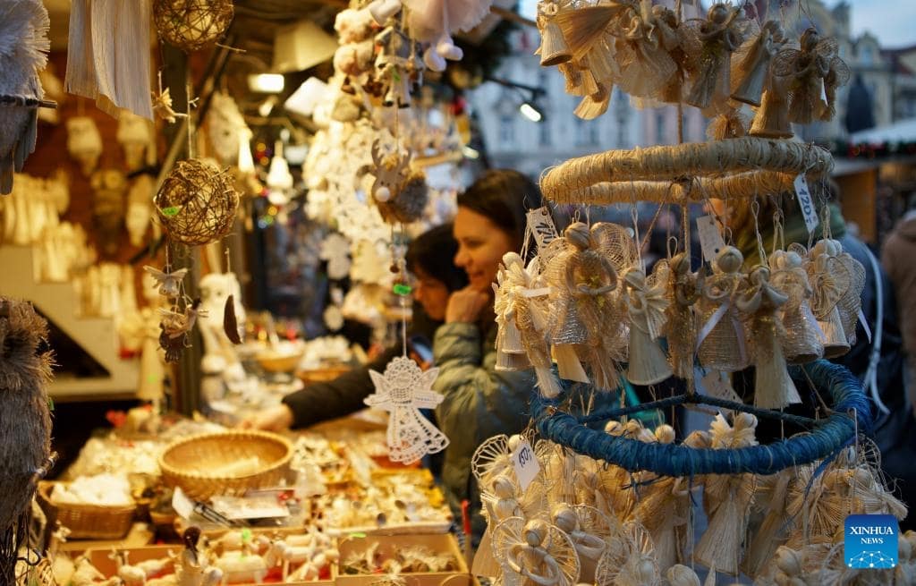 Du khách mua sắm, lựa đồ trang trí Giáng sinh trong hội chợ ở thủ đô Prague. Ảnh: Xinhua