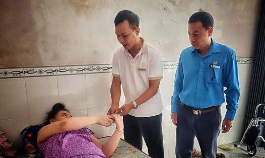 Đại diện Quỹ XHTT Tấm lòng Vàng trao tiền hỗ trợ của bạn đọc Báo Lao Động gửi đến gia đình chị Nguyễn Thị Quỳnh Như. Ảnh: Hoàng Lộc