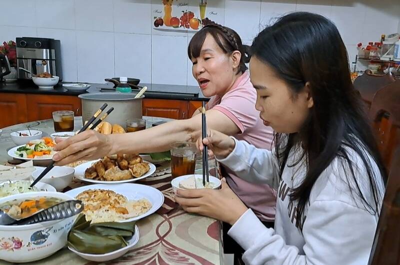 Bữa cơm ấm cúng của sinh viên Lào cùng ba mẹ nuôi. Ảnh: Nguyễn Linh