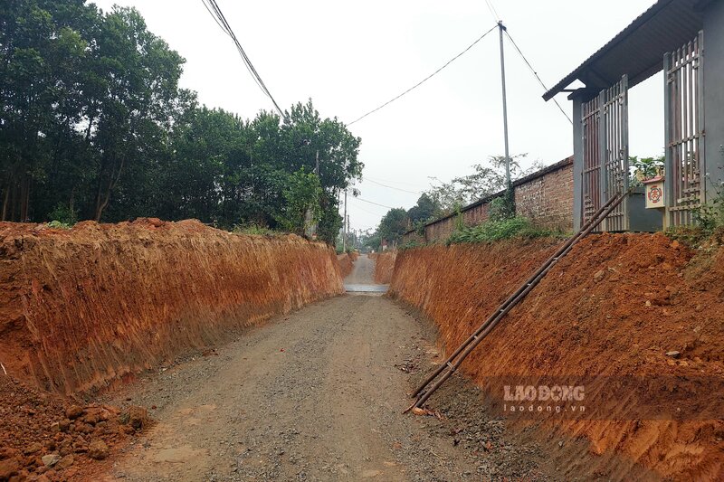 Tuyến đường liên xã trước kia cao bằng chân tường vào nhà ông Cương (bên phải), nay phải hạ thấp xuống để có thể đấu nối với đường liên vùng. Ảnh: Tô Công.