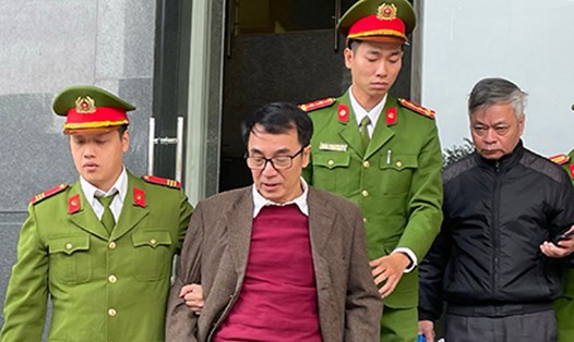 Cựu Cục Phó Trần Hùng (áo đỏ) bị dẫn giải ở phiên tòa phúc thẩm. Ảnh: Quang Việt
