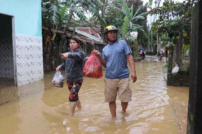 Mưa ngừng, người dân lội nước đi mua thức ăn. Ảnh: Nguyễn Linh