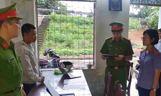 Cơ quan Cảnh sát điều tra tống đạt các quyết định đối với Nguyễn Hồng Đức (áo trắng). Ảnh: Bảo Ngọc
