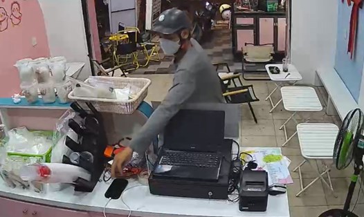 Tên trộm mua trà sữa rồi trộm điện thoại nhân viên quán. Ảnh cắt từ camera