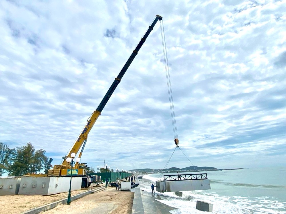 Xe cẩu đưa cầu phao xuống biển để làm sân khấu biển. Ảnh: Duy Tuấn