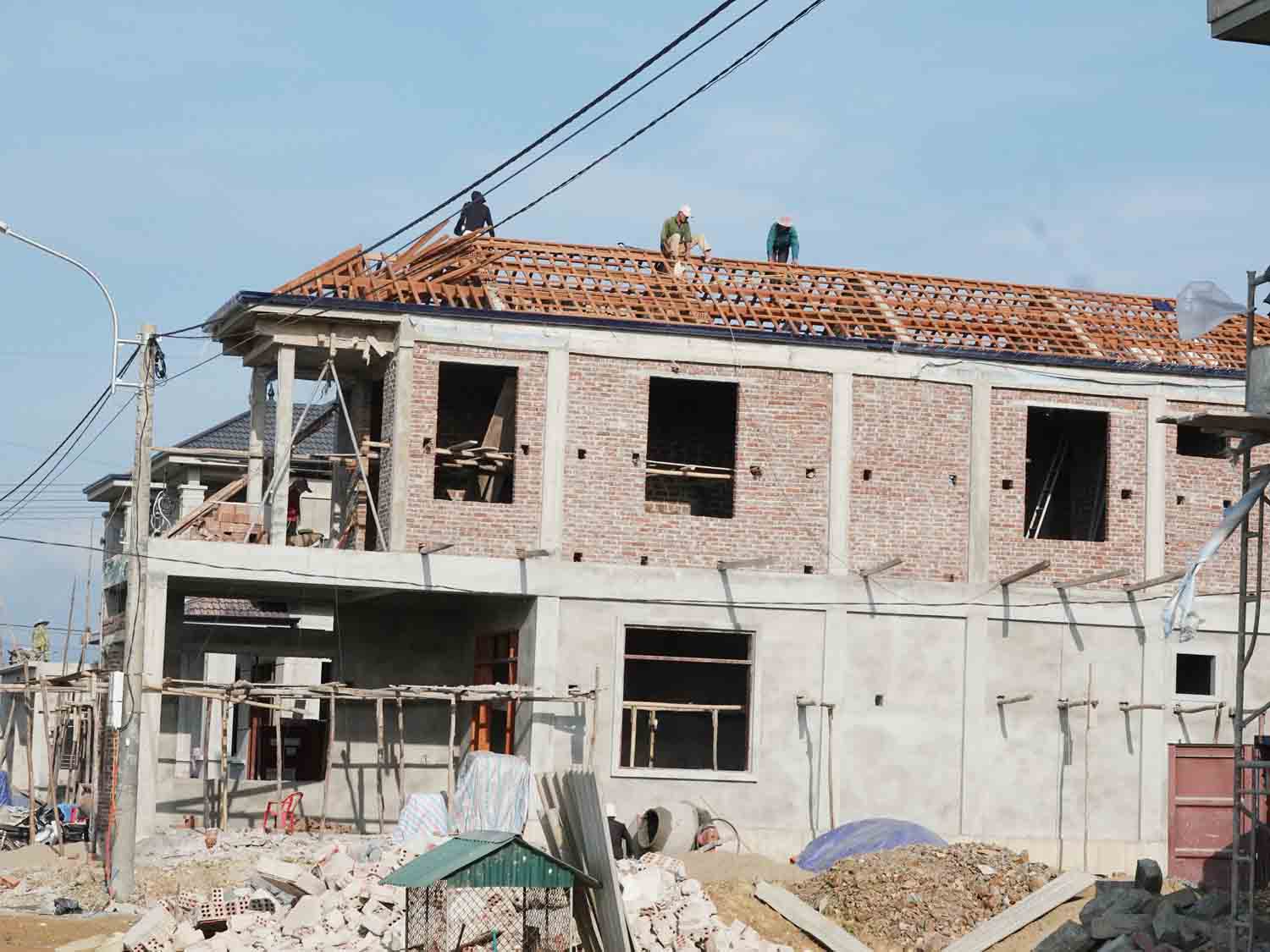 Người dân đang xây dựng nhà tại khu tái định cư cao tốc Bắc - Nam thuộc xã Kim Song Trường, huyện Can Lộc, tỉnh Hà Tĩnh. Ảnh: Trần Tuấn.