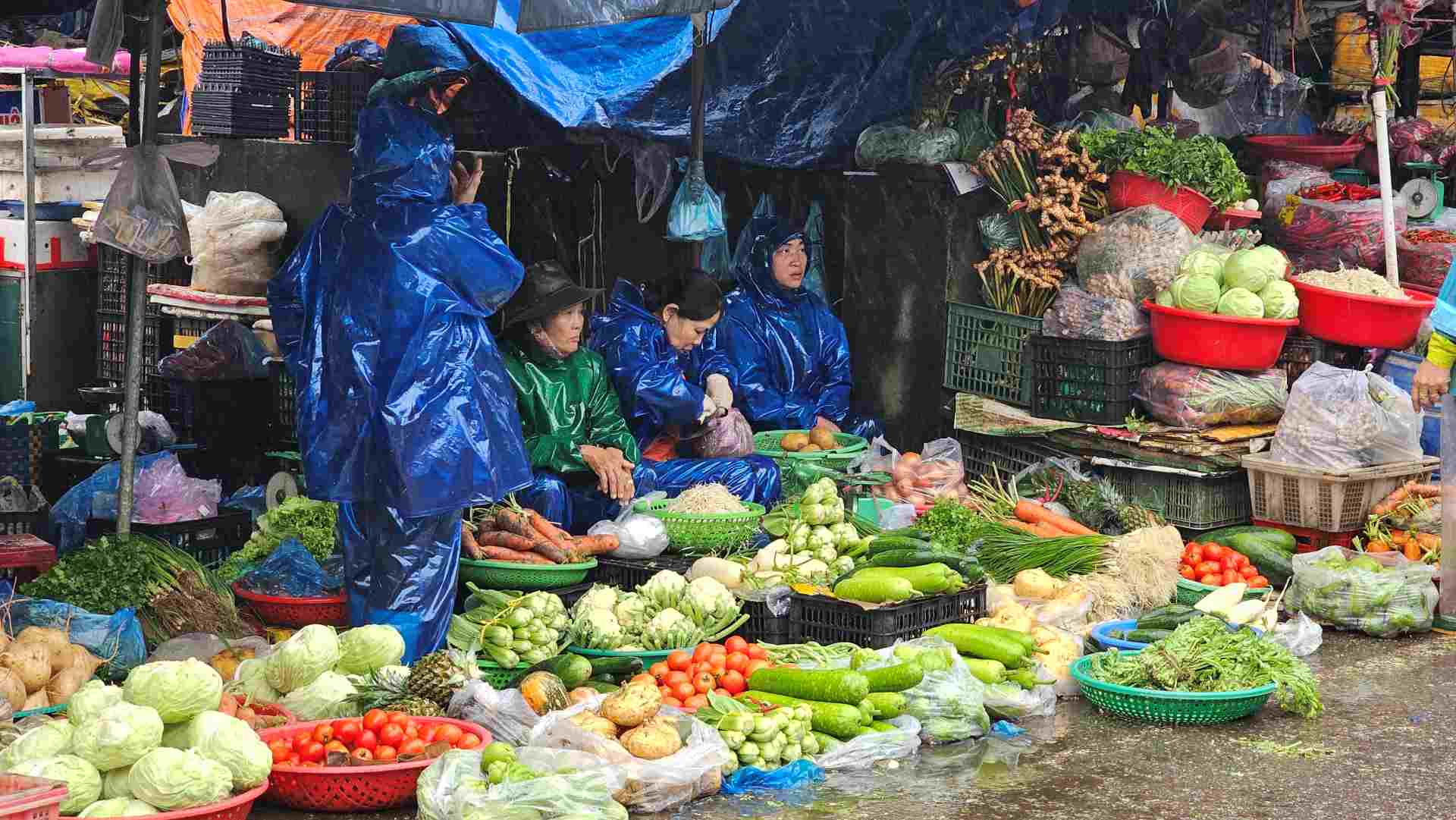 Chợ Đông Ba phía đường Chương Dương, các tiểu thương miệt mài bán hàng, ai nấy đều mặc trên mình chiếc áo mưa. 