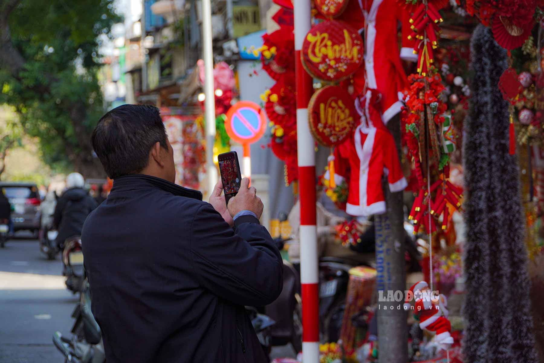 Người dân khi đi qua phố Hàng Mã đều rất thích thú khi cảm nhận không khí của Tết đang gần kề, ai cũng giơ chiếc điện thoại lên để lưu lại những hình ảnh đẹp nhất.