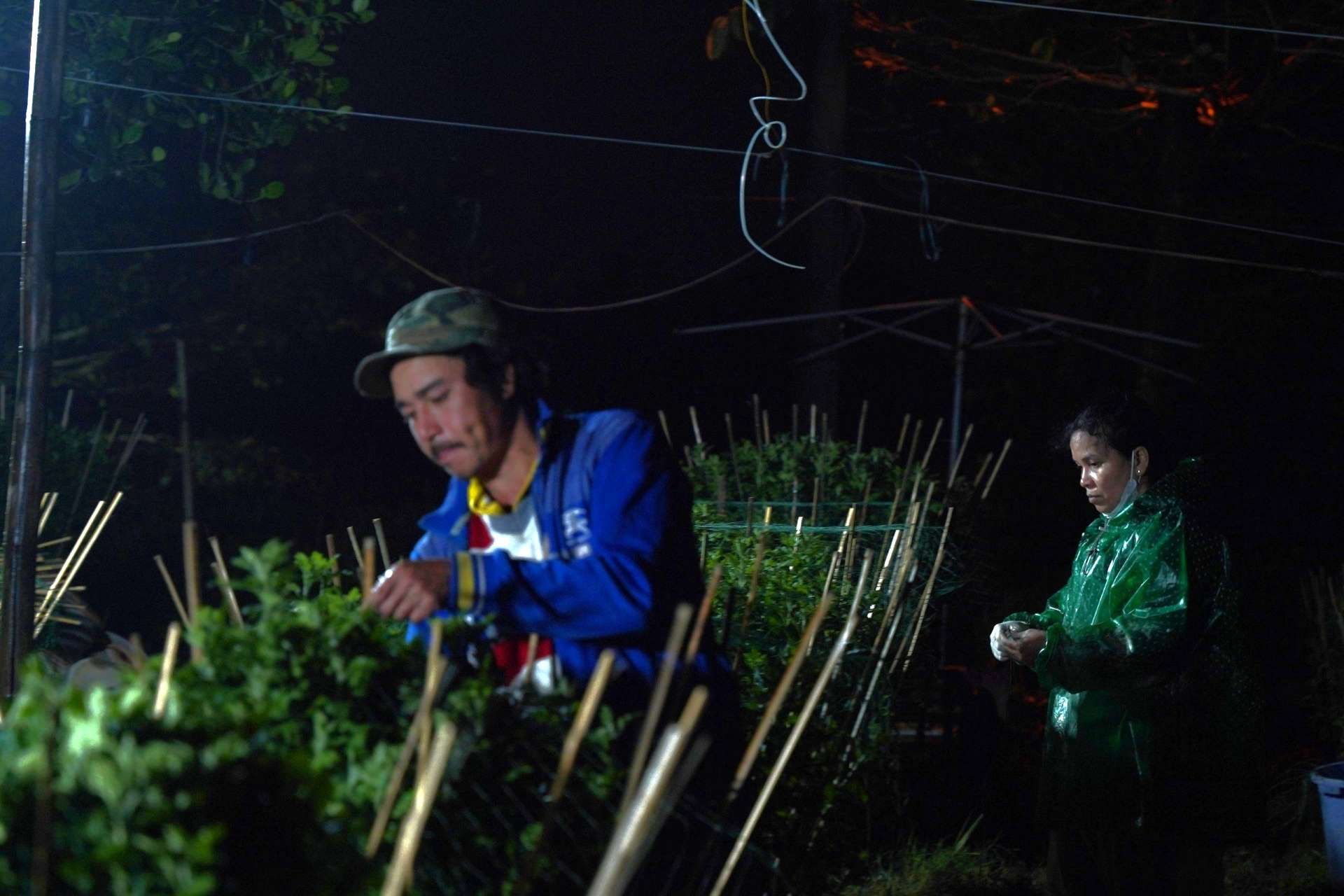 Anh Nguyễn Văn Quang cùng vợ thắp điện kiểm tra, cố định lại hình dáng của chậu hoa.