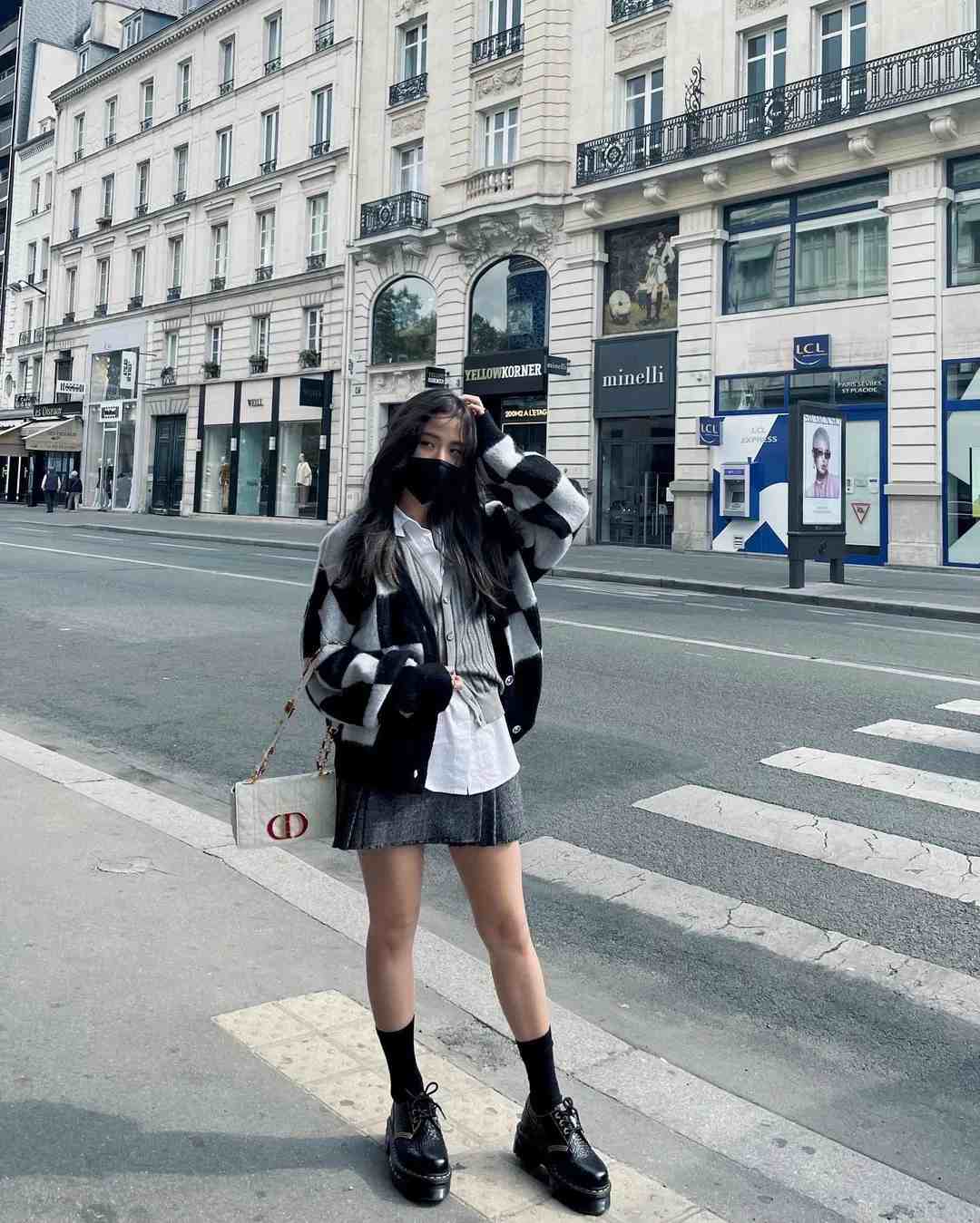 Jisoo dạo chơi trên đường phố Paris với phong cách nữ sinh năng động. Cô mặc áo len dáng cardigan. Cách phối màu từ trắng, đen, xám giúp nữ ca sĩ có tổng thể phong cách hài hòa. Ảnh: Naver.