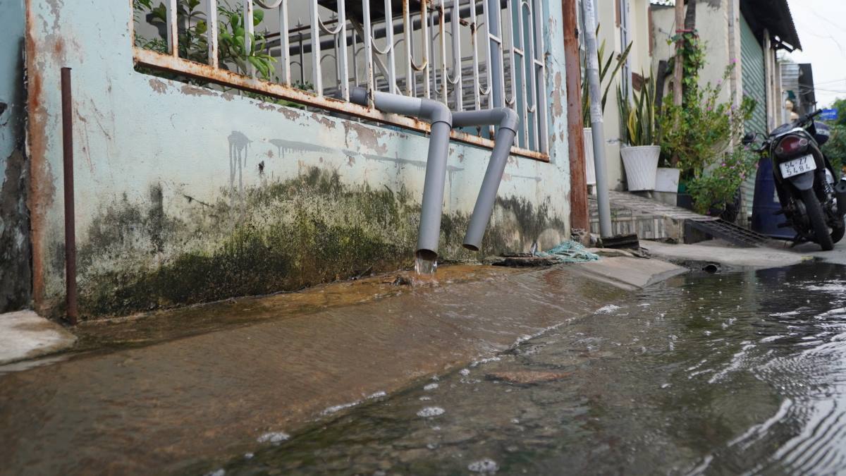 Nước tràn vào nhà một hộ dân trên hẻm 803 Huỳnh Tấn Phát, buộc chủ nhà phải dùng máy bơm để hút nước đổ ra ngoài.