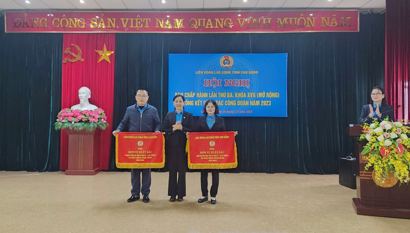 2 tập thể nhận cờ thi đua của LĐLĐ tỉnh Cao Bằng. Ảnh: Tân Văn.