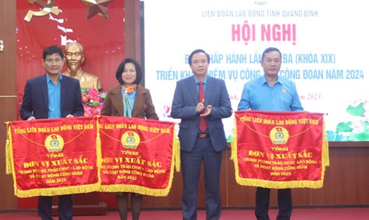 Chủ tịch LĐLĐ tỉnh Quảng Bình Phạm Tiến Nam trao cờ của Tổng LĐLĐ Việt Nam cho các tập thể xuất sắc. Ảnh: Lê Phi Long